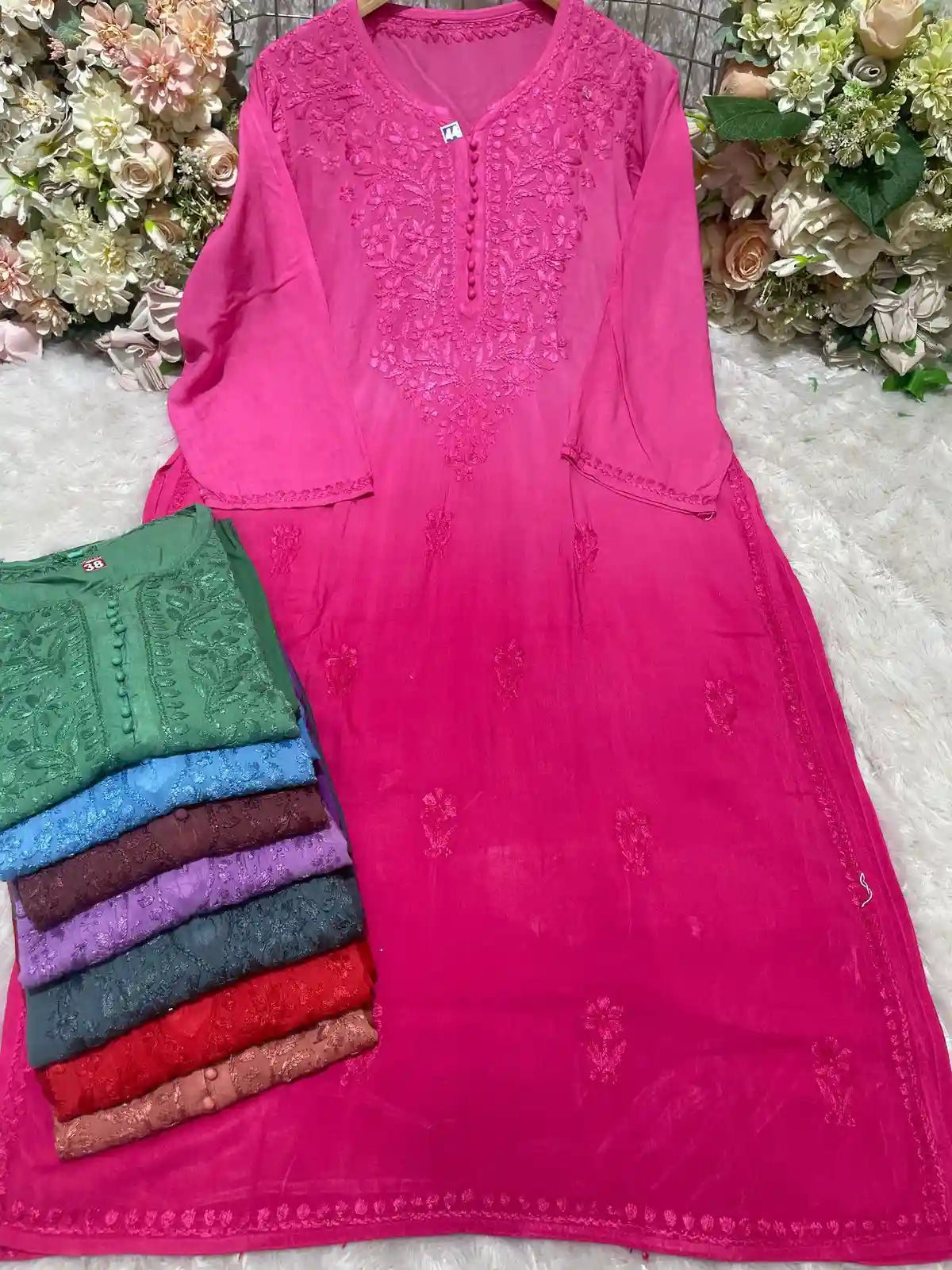 Stack of colorful embroidered ryon kurtis with detailed floral neck patterns and buttons