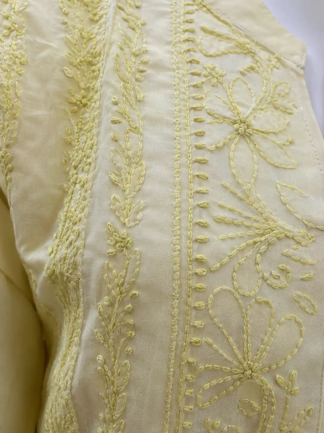 Close-up of intricate tone-on-tone Chikankari embroidery on yellow cotton kurti