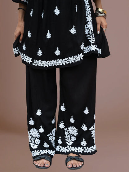 Model wearing flared rayon chikankari kurti with matching embroidered bottom