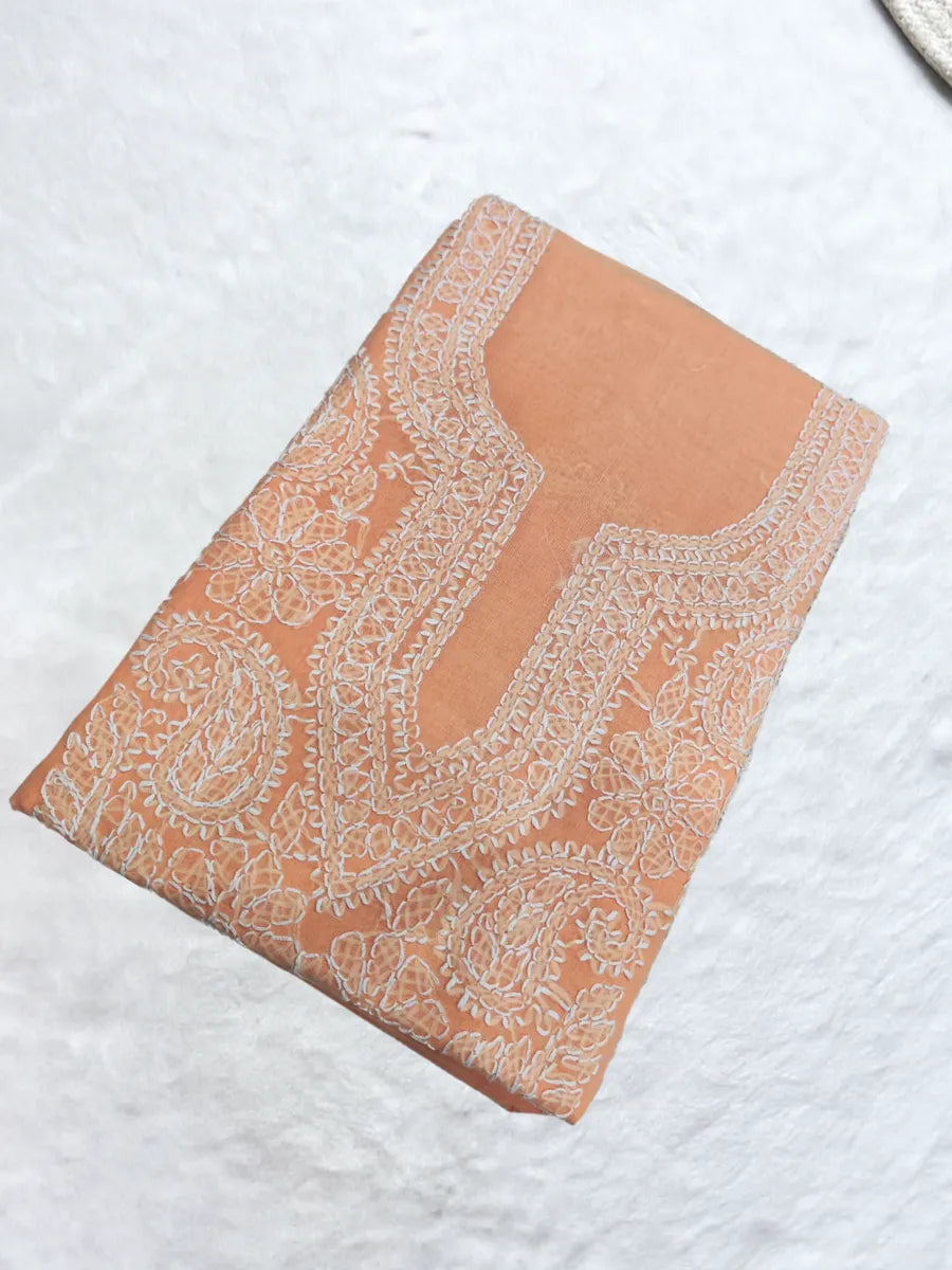 Peach blush cotton dress material with intricate shadow and fanda Chikankari embroidery in matching thread on soft voile cotton fabric, folded neatly on a textured surface.