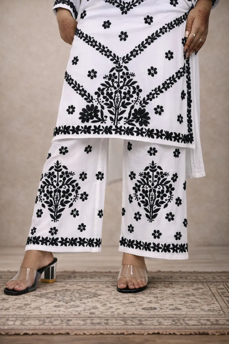 White chikankari kurti set with black floral embroidery worn with matching embroidered pants