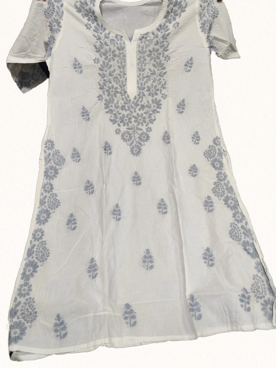 White mal cotton long kurti with fine Ghaspatti embroidery in frost grey thread, folded and displayed on a black background – Dniza Chikankari collection.