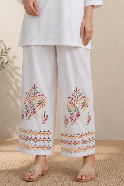 White rayon palazzo featuring colorful floral embroidery on the hem, soft rayon fabric, elastic waistband, and multicolor handcrafted-inspired thread work, perfect for pairing with chikankari kurtis and ethnic wear.
