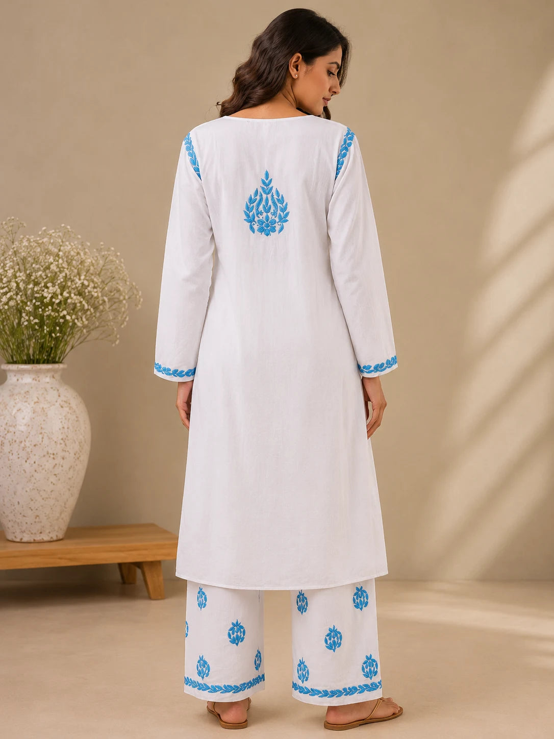 Women’s white embroidered kurta palazzo set with intricate sky blue floral work